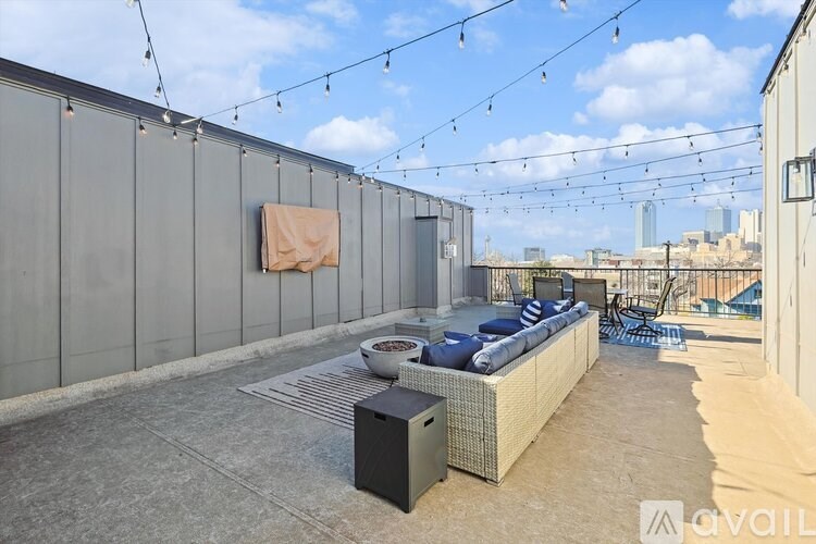 A patio with a couch, table, and string lights.