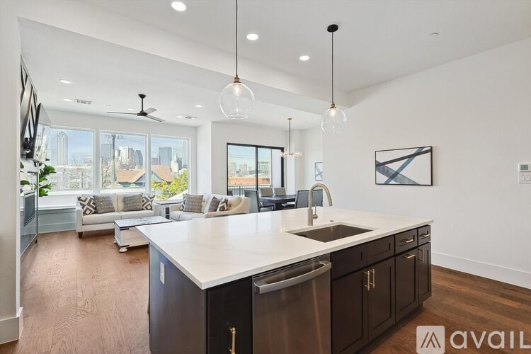 A modern kitchen with dark wood cabinets and a white countertop.