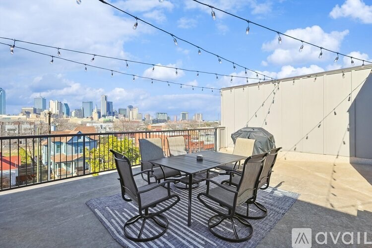 A patio with a table and chairs overlooking a city skyline.