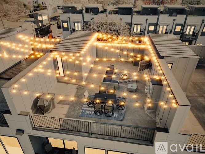 A balcony with lights and a table set up for dining.