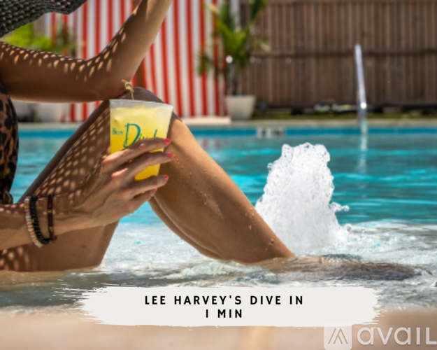 A woman in a leopard print bikini is holding a drink while sitting in a pool.