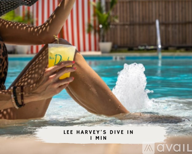 A woman in a leopard print bikini is holding a drink while sitting in a pool.