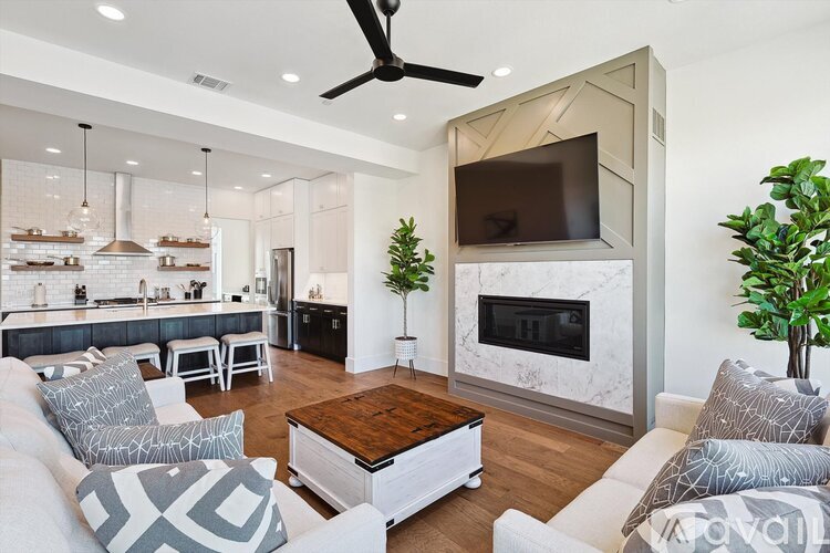 A modern living room with a fireplace and a television mounted on the wall.