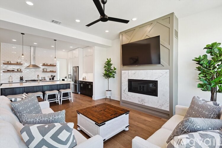 A modern living room with a fireplace and a television mounted on the wall.