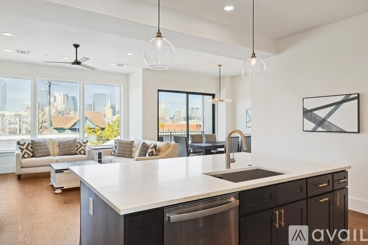 A modern kitchen with a large island and a view of the city.