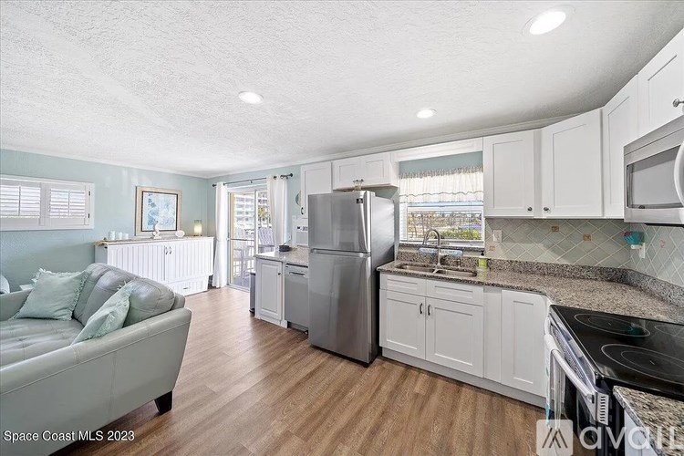 A kitchen with a refrigerator, stove, and sink.