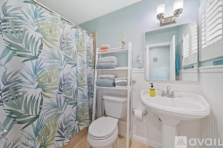 A bathroom with a toilet, sink, and shower curtain.
