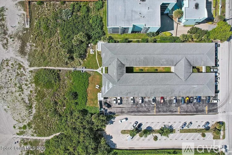 An aerial view of a parking lot with a large building in the background.