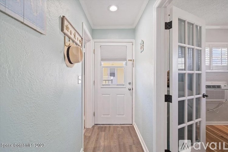 A hallway with a white door and a wall-mounted mailbox.
