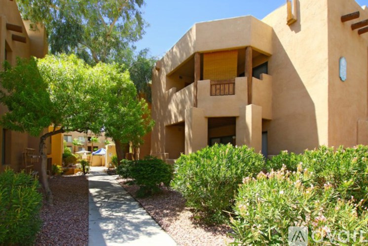 A building with a pathway and greenery in front.