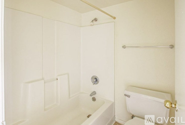 A white bathroom with a tub, toilet and sink.