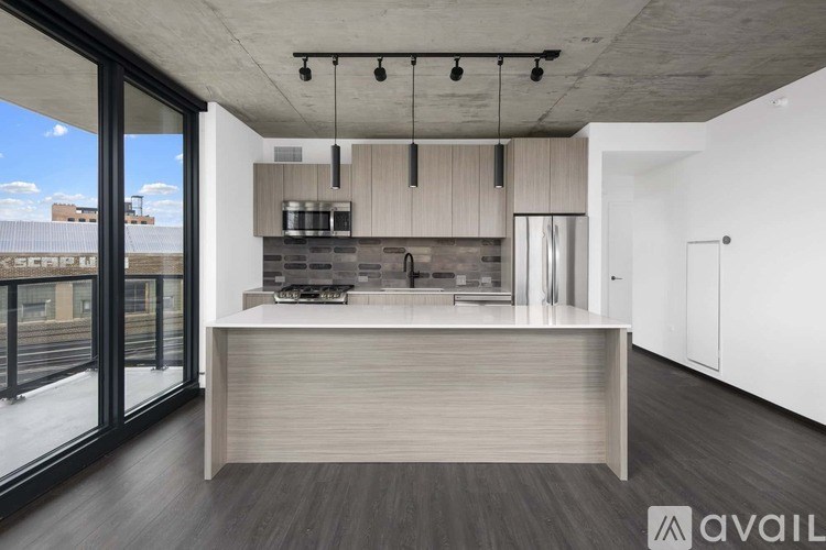A modern kitchen with a large island and a view of the city.