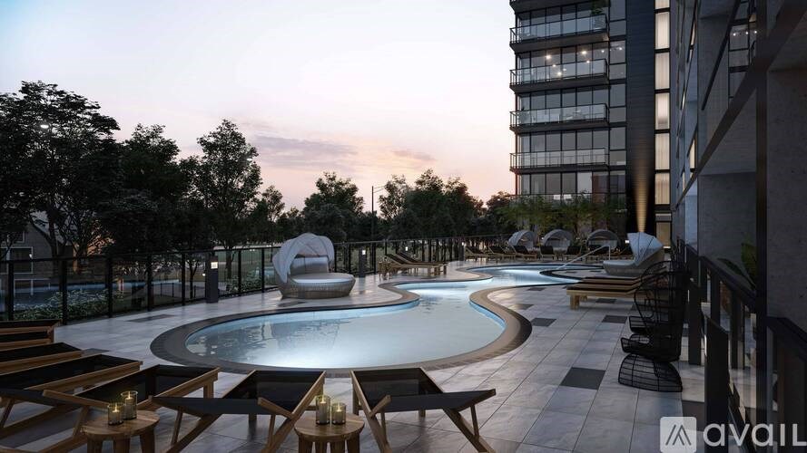 A modern outdoor pool area with lounge chairs and a large sculpture.