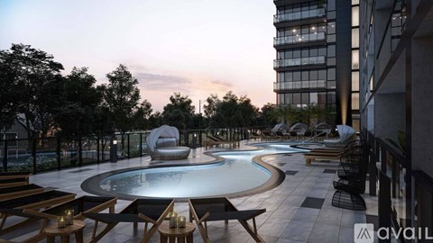 A modern outdoor pool area with lounge chairs and a large sculpture.