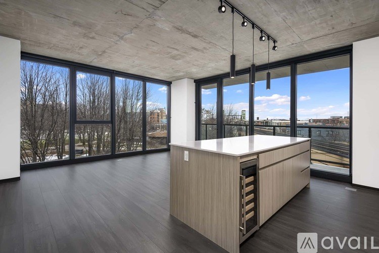 A modern kitchen with a large island and a view of the outdoors.