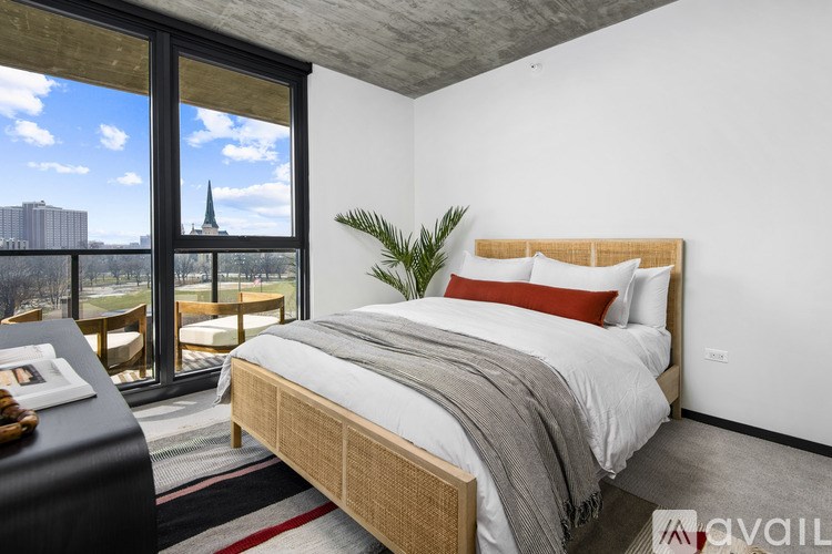 A bedroom with a large bed and a view of a cityscape through the window.
