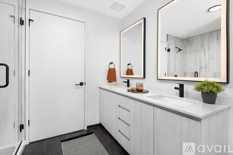 A bathroom with a white door, sink, and mirror.