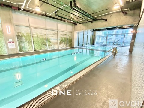 A large indoor swimming pool with a glass wall on one side.