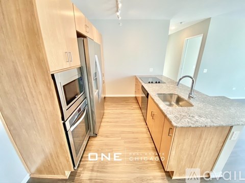 A kitchen with wooden cabinets and stainless steel appliances is available for rent in Chicago.