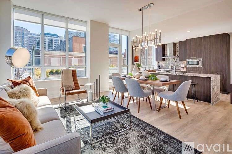 A modern living room with a grey sofa, a coffee table, and a dining table with chairs.