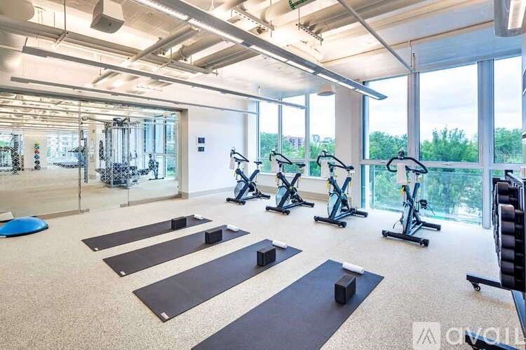 A gym with exercise equipment and yoga mats.
