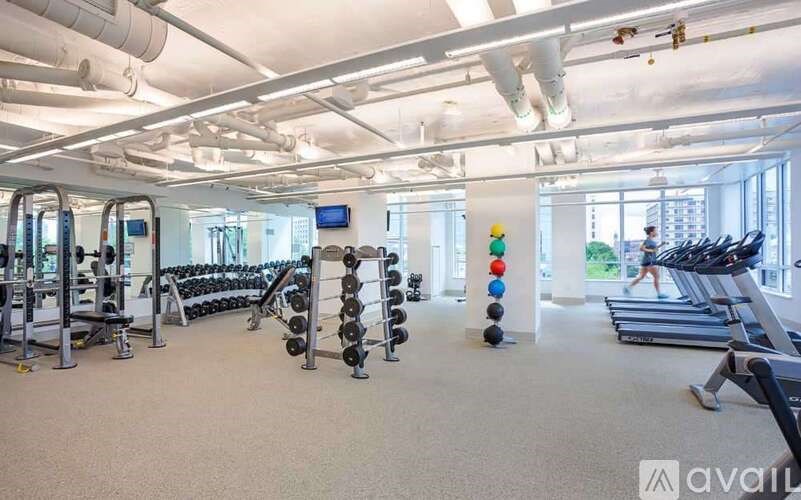 A gym with treadmills, weights, and exercise equipment.