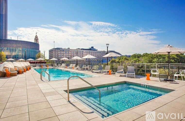 A large outdoor swimming pool with sun loungers and umbrellas.