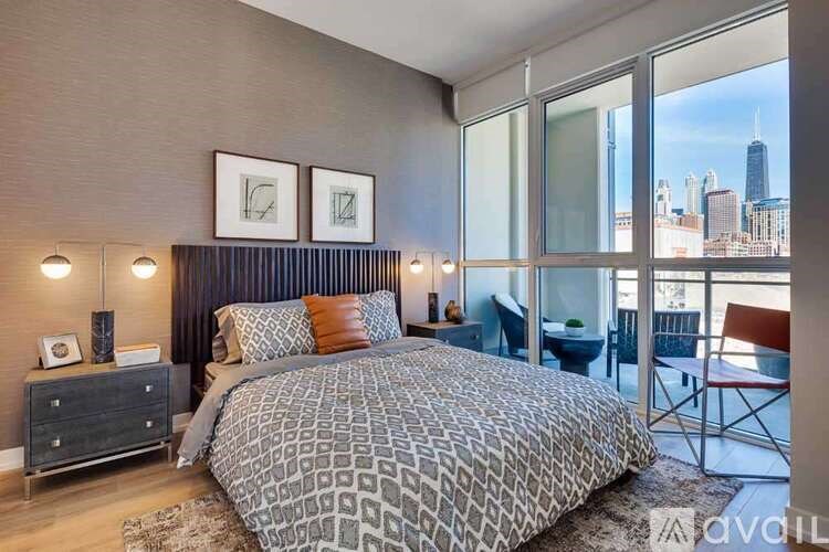 A bedroom with a large bed and a view of the city skyline.