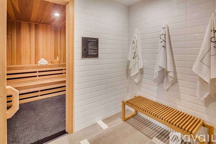 A wooden bench sits in a room with white walls and a wooden door.