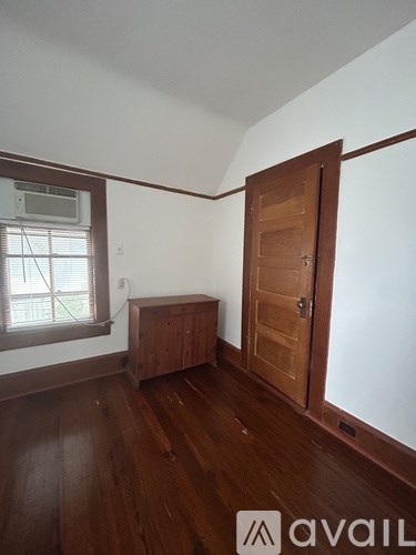 A room with a wooden floor and a brown door.