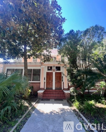 A house with a brown door and a tree in front.