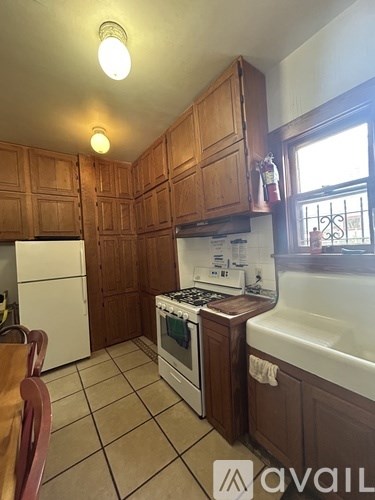 A kitchen with wooden cabinets and a white stove top oven.