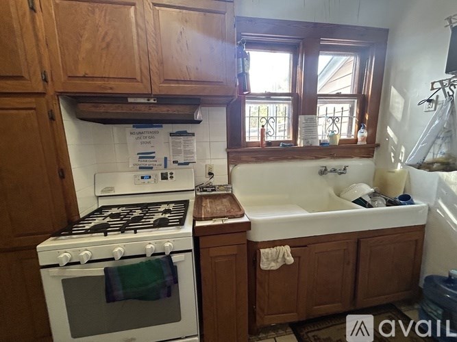 A kitchen with a white stove and a white sink.