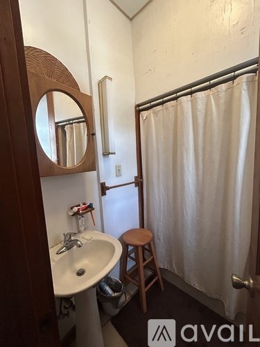 A bathroom with a sink, mirror, and shower.