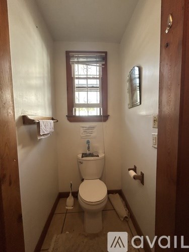 A small bathroom with a toilet and a window.