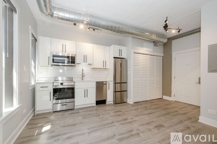 A kitchen with white cabinets and stainless steel appliances.