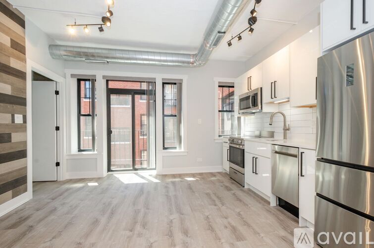 A kitchen with white cabinets and a stainless steel refrigerator.