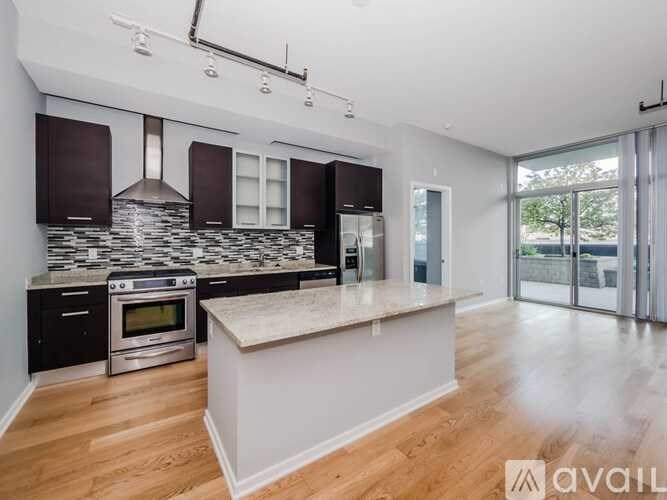 A modern kitchen with a stone backsplash and wooden floors.