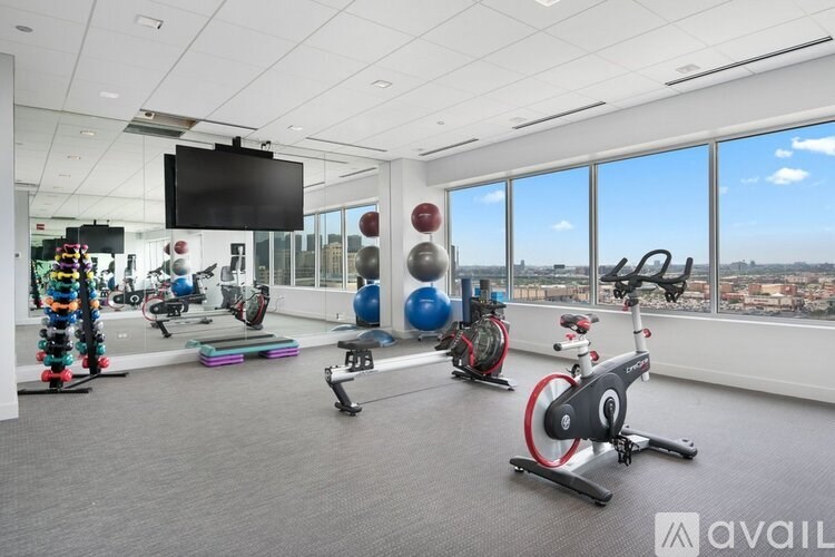 A gym with exercise equipment and a view of the city.