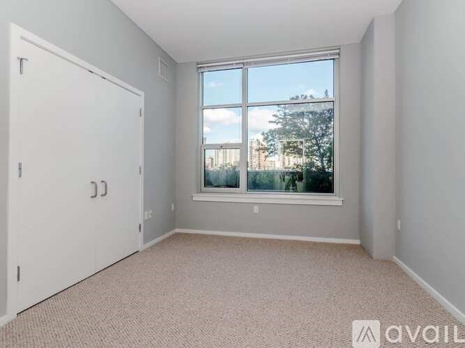 A room with a large window and a white door.