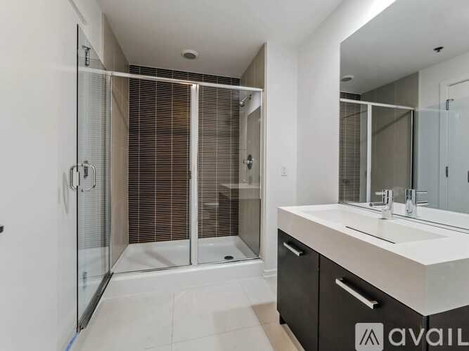 A modern bathroom with a walk-in shower and a large mirror.