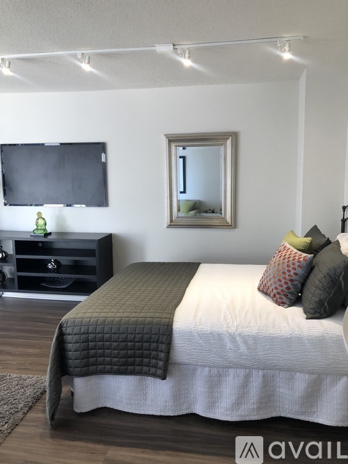 A bedroom with a bed, a dresser, and a mirror.