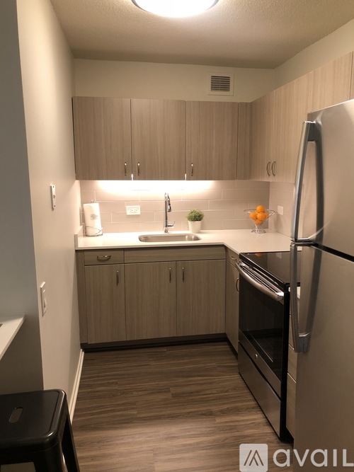 A kitchen with wooden cabinets and a black fridge.