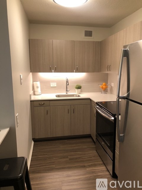 A kitchen with wooden cabinets and a black fridge.