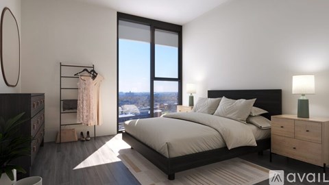 A bedroom with a large bed, a dresser, and a window overlooking a cityscape.