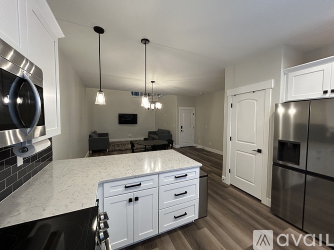 A modern kitchen with white cabinets and a marble countertop.