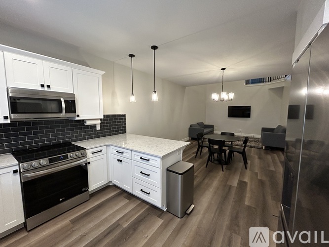 A kitchen with white cabinets and black countertops.