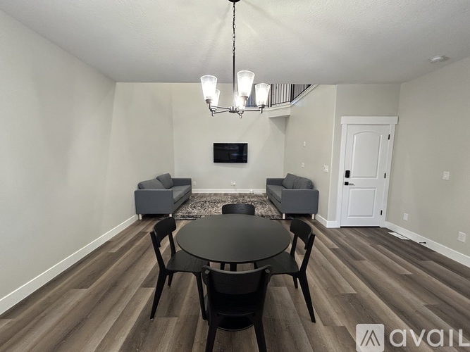 A living room with a black table and chairs and a television.