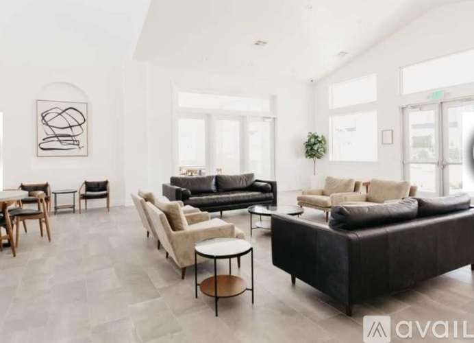 A modern living room with a black leather sofa and wooden furniture.