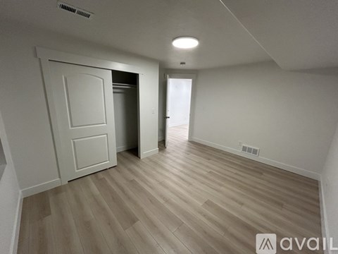 A room with wooden flooring and a white door.
